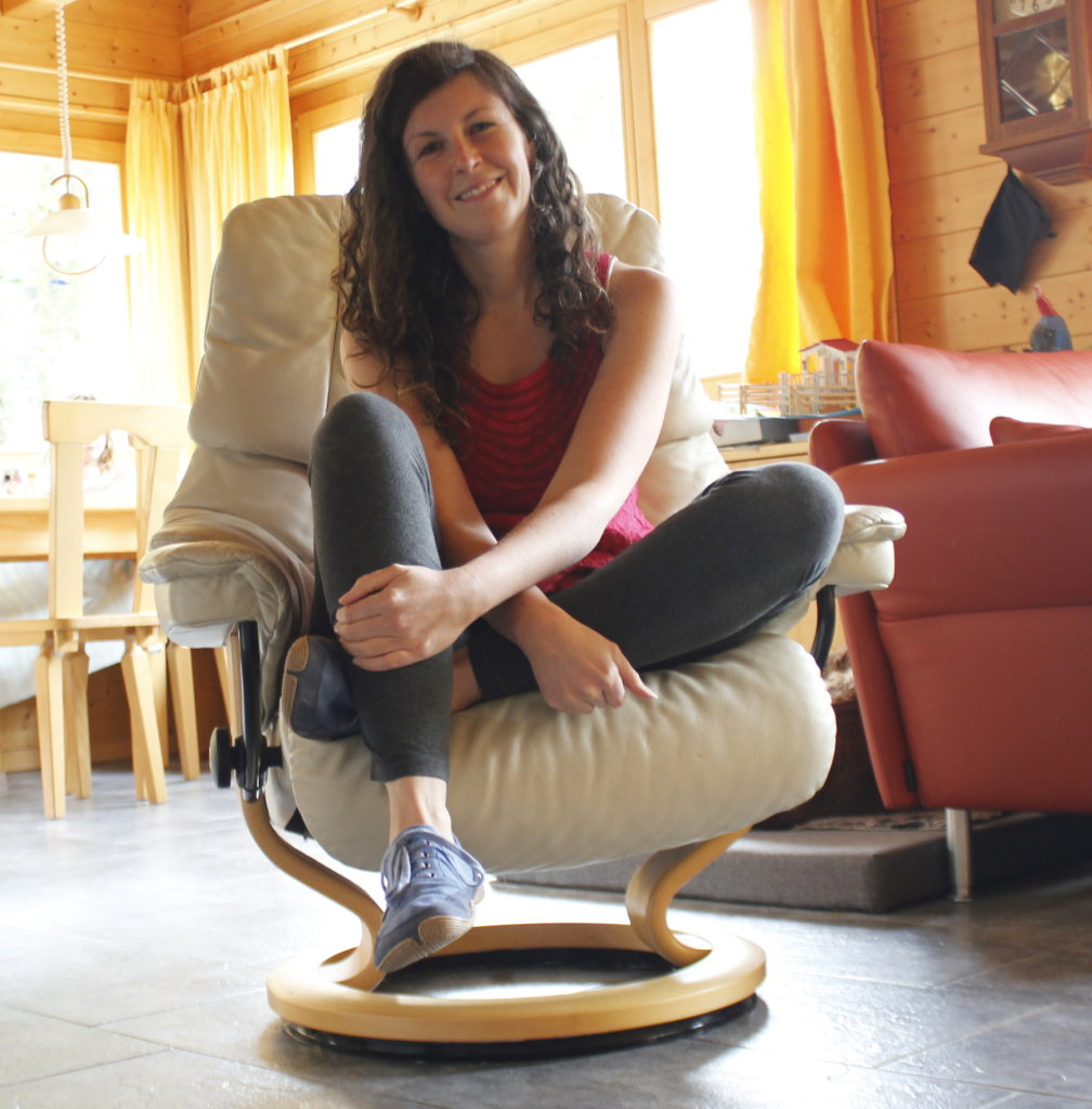 woman sitting on chair smiling wearing barefoot shoes